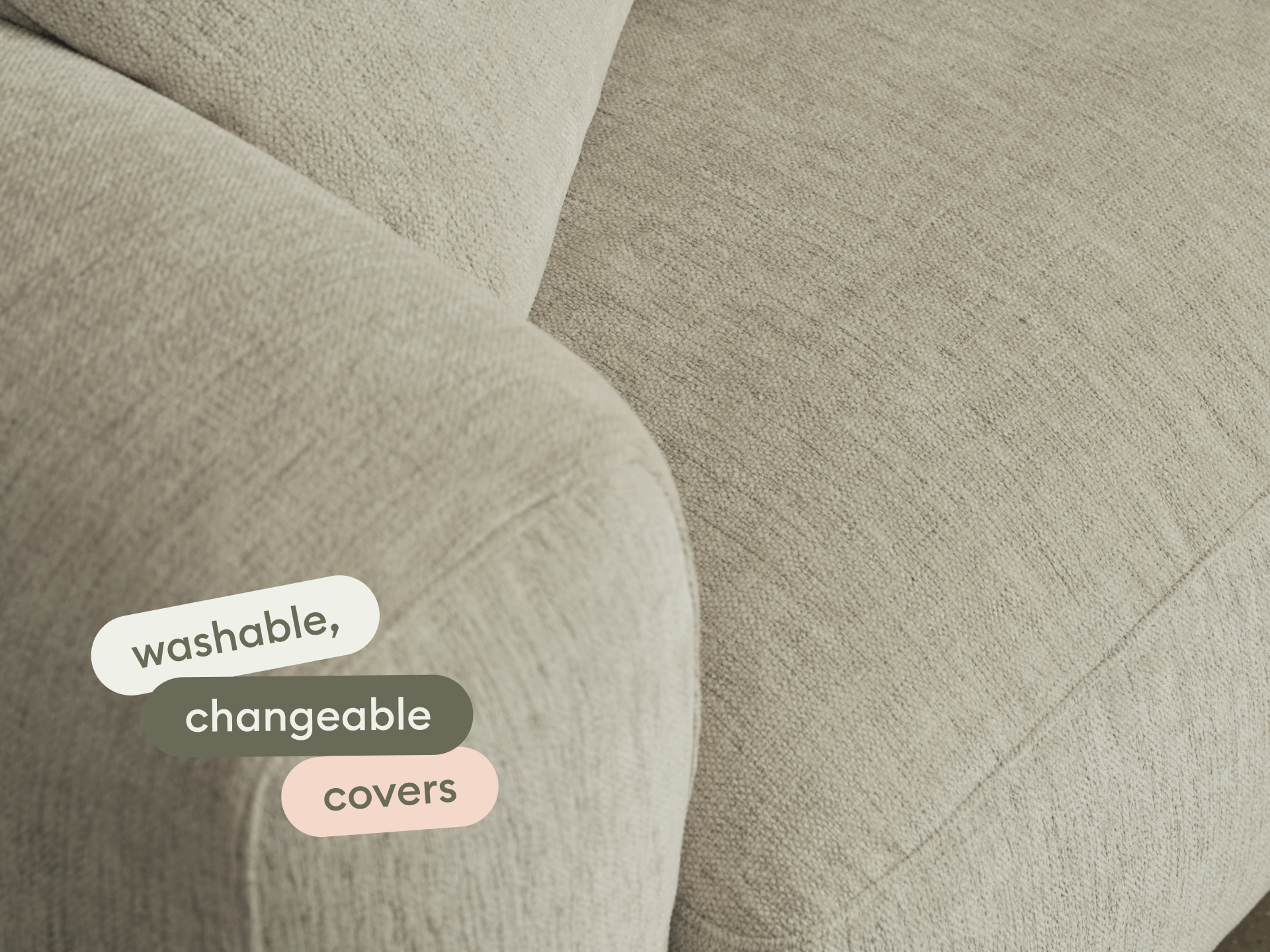 Modern beige fabric sofa with washable, changeable covers. Features soft, curved arms and a textured finish. Perfect for luxurious, versatile living spaces.
