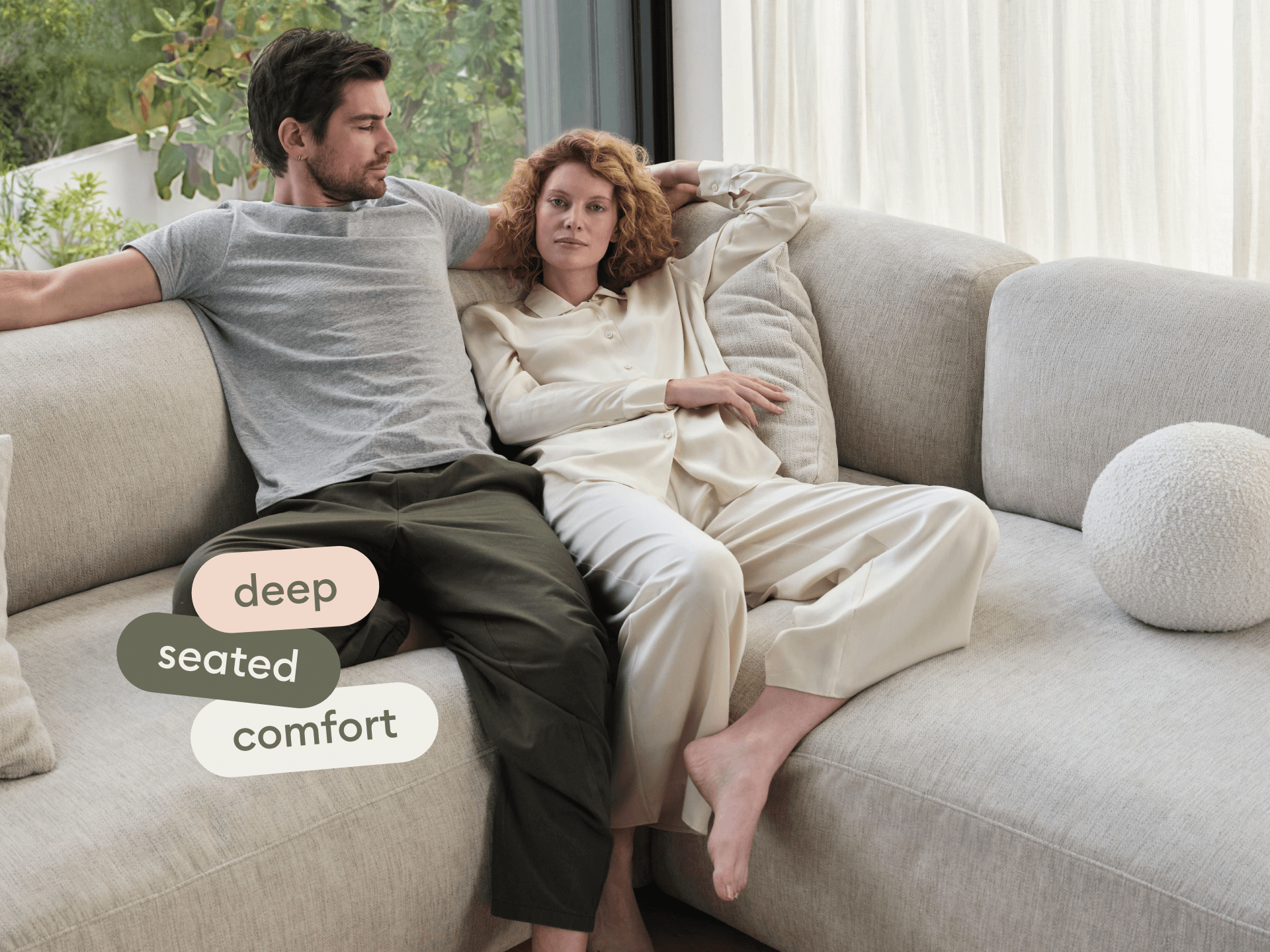 Luxurious L-shaped sectional sofa in textured light grey fabric, featuring deep, plush cushions. Set in a serene modern living space with abundant natural light.