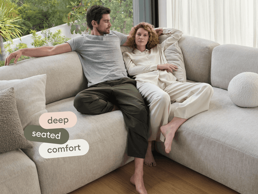 Luxurious cream sectional sofa in plush fabric, featuring deep seats and a modular design. Set in a modern living area with floor-to-ceiling windows.
