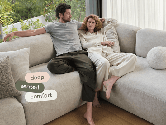 Luxurious L-shaped sectional sofa, upholstered in plush beige fabric, features deep seating and plush cushions. Positioned in a sunlit, modern living space.
