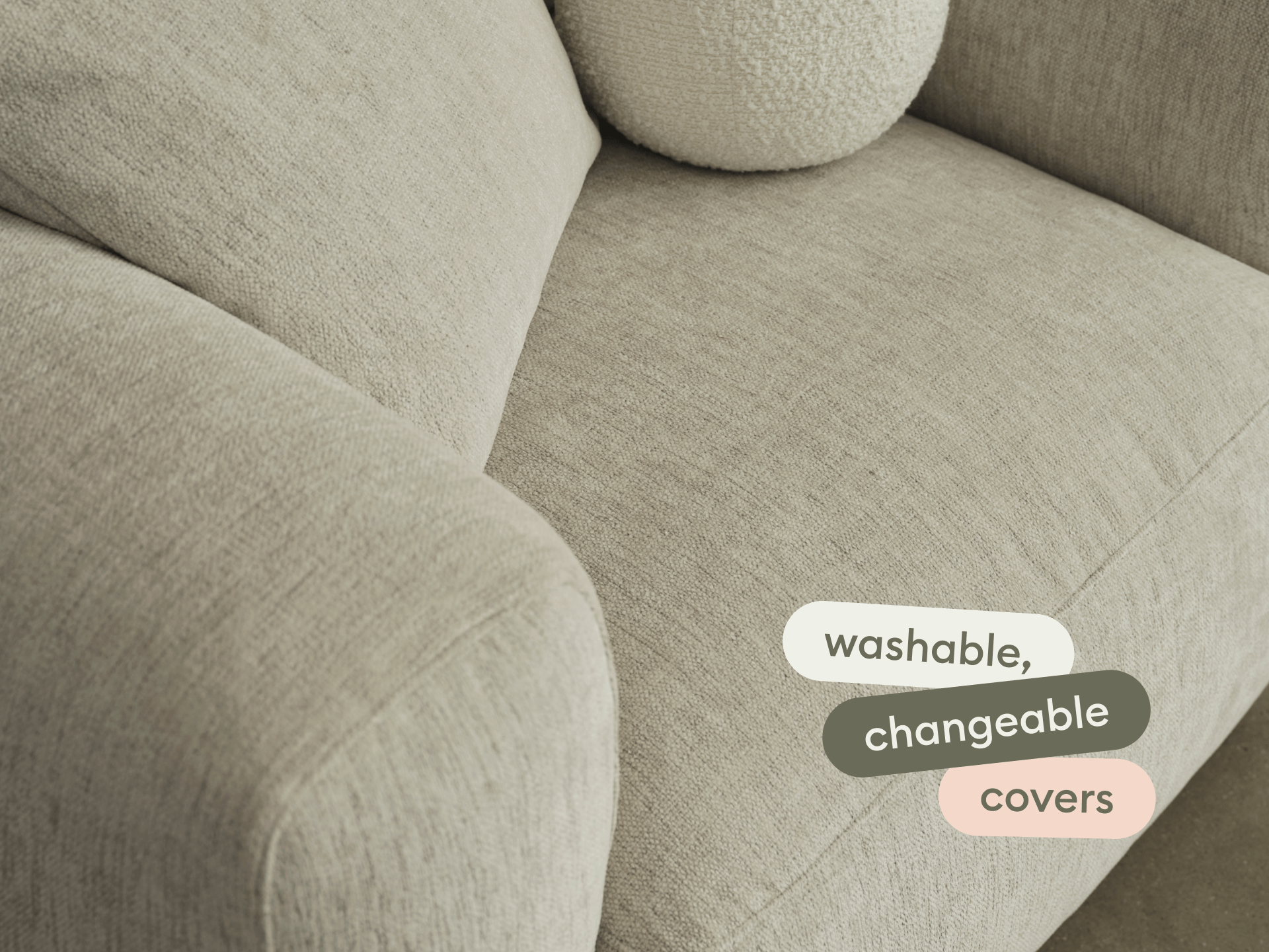 Modern beige fabric sofa with plush armrest and washable, changeable covers. Seamlessly blends into an elegant living room setting.