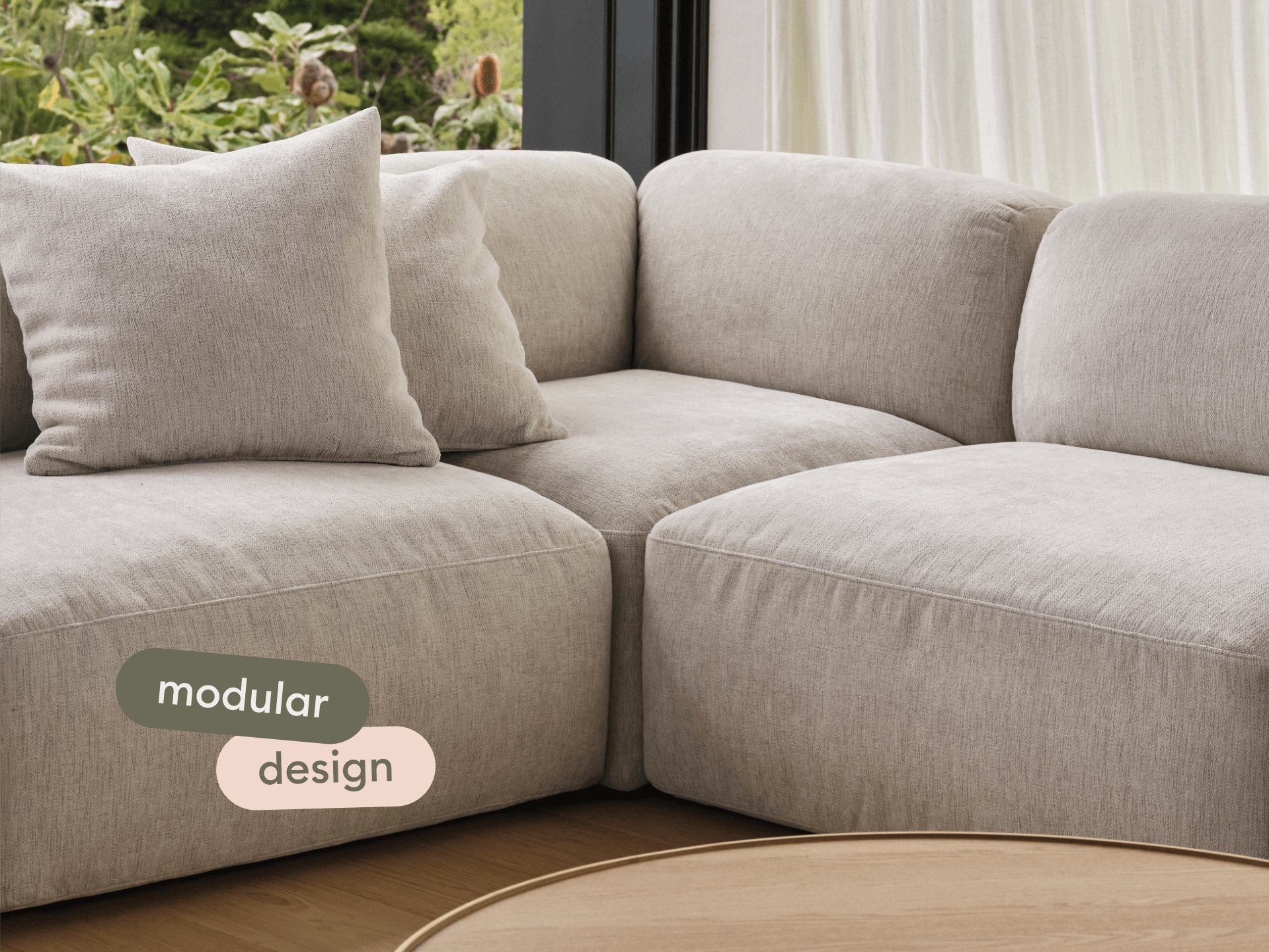 Modular sofa in light beige linen with plush cushions, sleek lines, and minimalist elegance, set against a window with lush garden views.