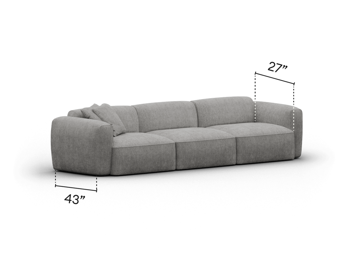 Luxurious grey upholstered sectional sofa, featuring plush cushions and rounded armrests, set in a contemporary living room. Dimensions: 113" wide, 27" high.