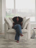 person lounging on comfy white sofa in bright living room
