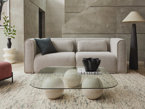 Woman effortlessly converting the Koala Bangalow sofa bed from a stylish sofa to a comfortable bed, showcasing ease of use in a cozy living room.