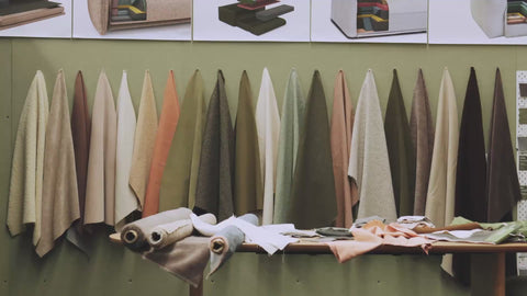 Close ups of different fabrics and people inspecting them